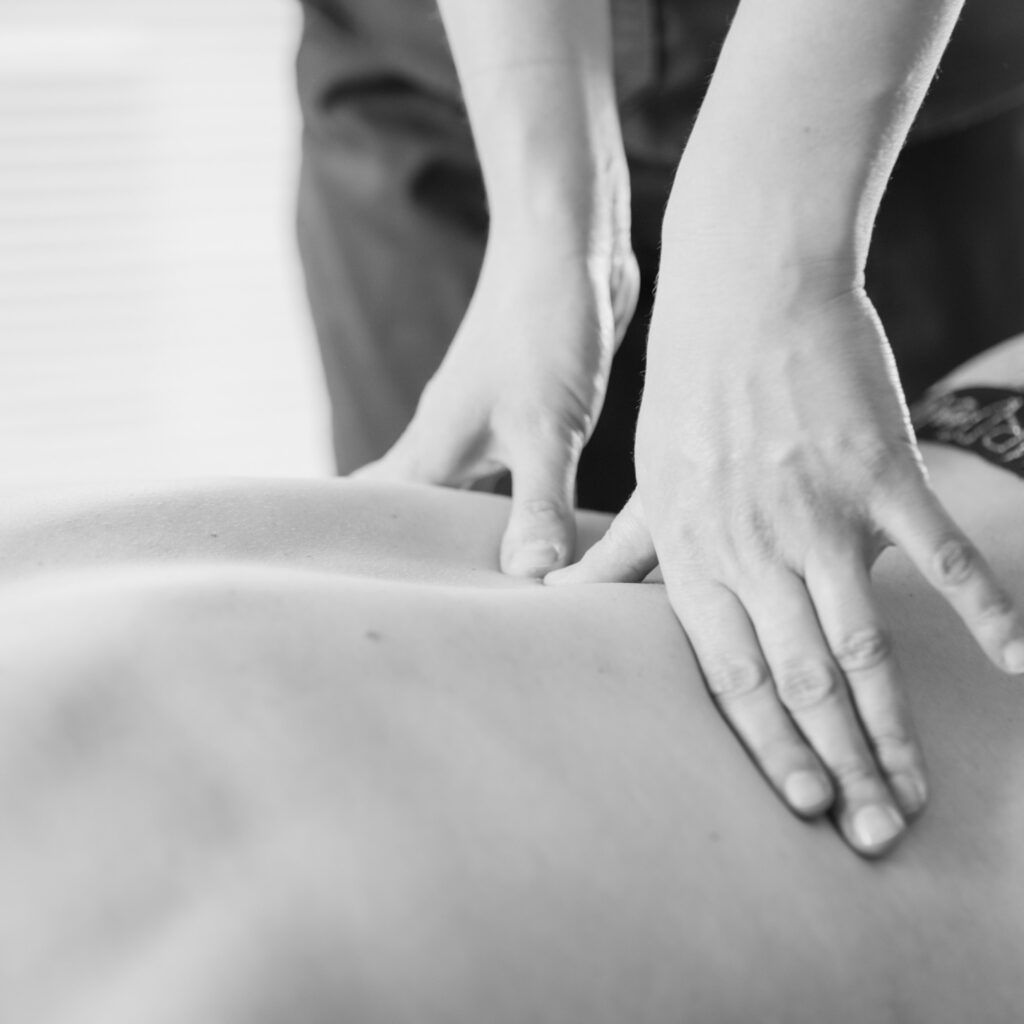 ucisk kciukami na kręgosłupie pacjenta - terapia manualna w nadolicach małych